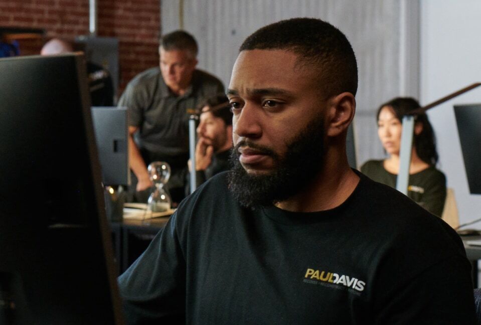 Paul Davis Restoration staff member at a computer assisting a customer